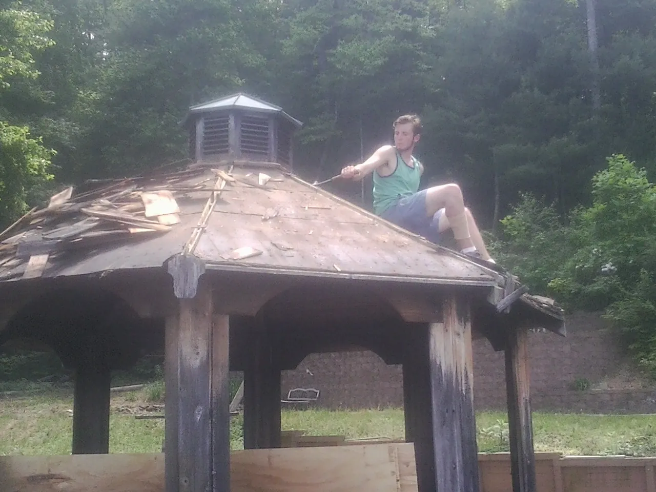 Tearing the old roof off a wooden gazebo before new shakes in Denver